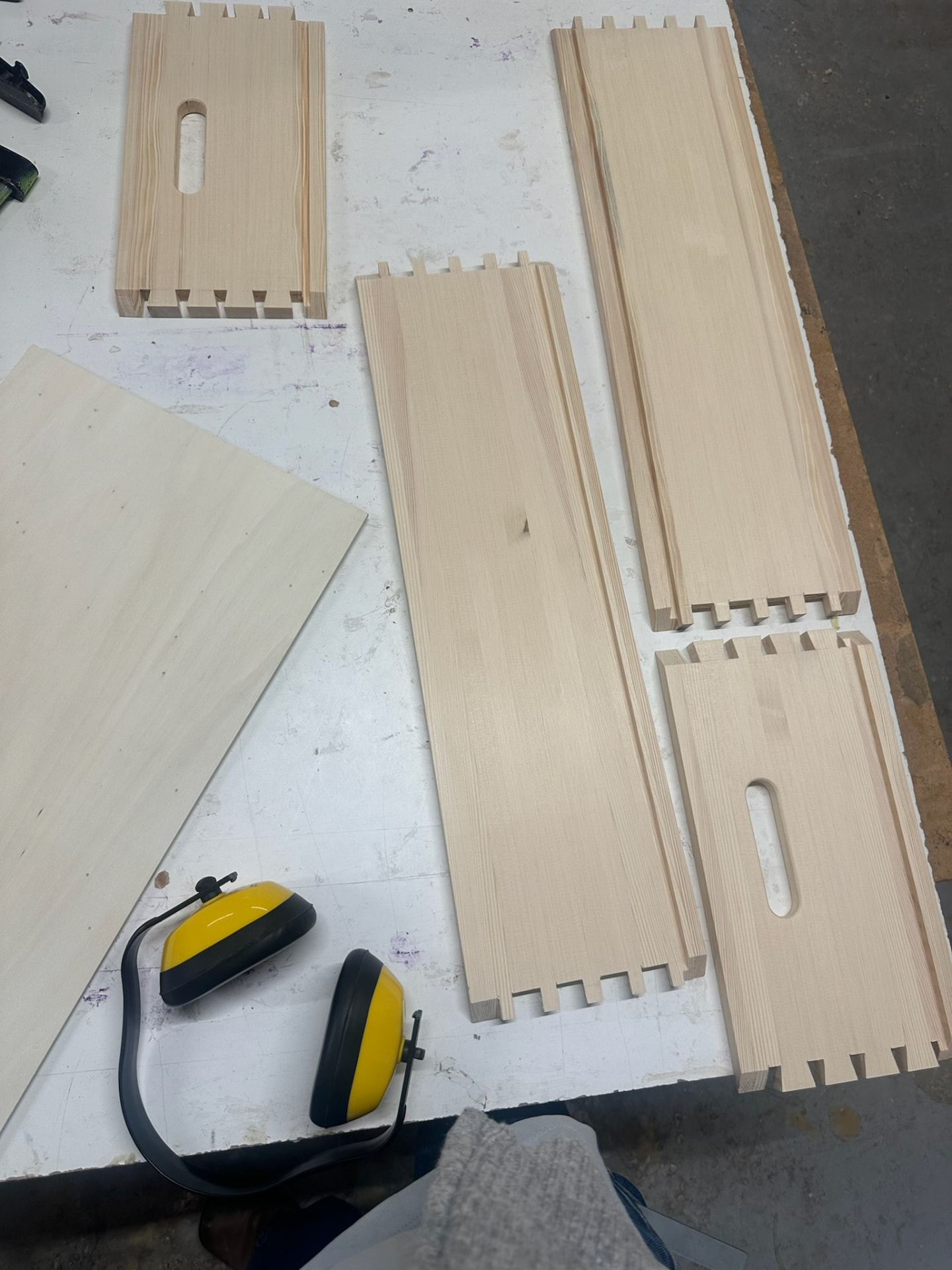 Pine box components laid out on the bench with dovetails cut and handles routed.