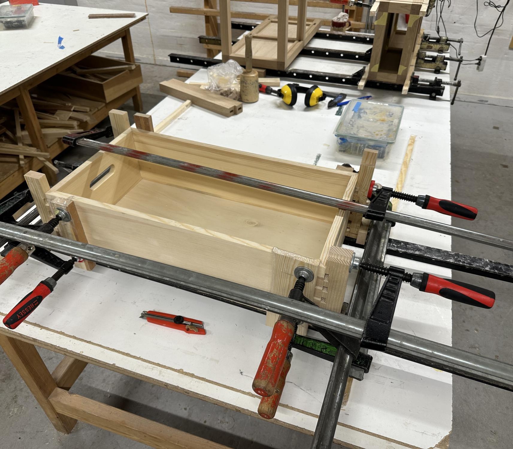 Toolbox clamped from several directions on the bench while the dovetailed corners are glued.