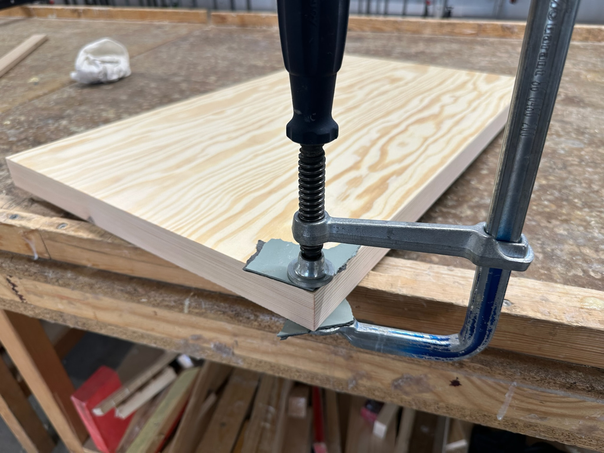 A pine panel clamped at a mitred corner on the workbench.