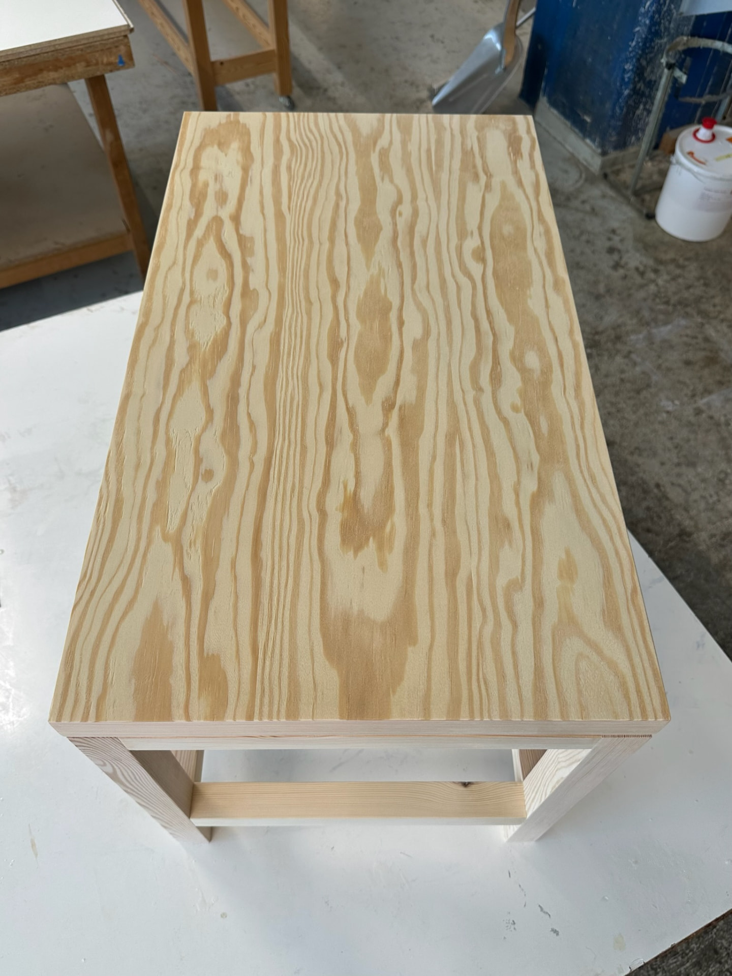Assembled pine stool seen from above, showing the grain of the seat.